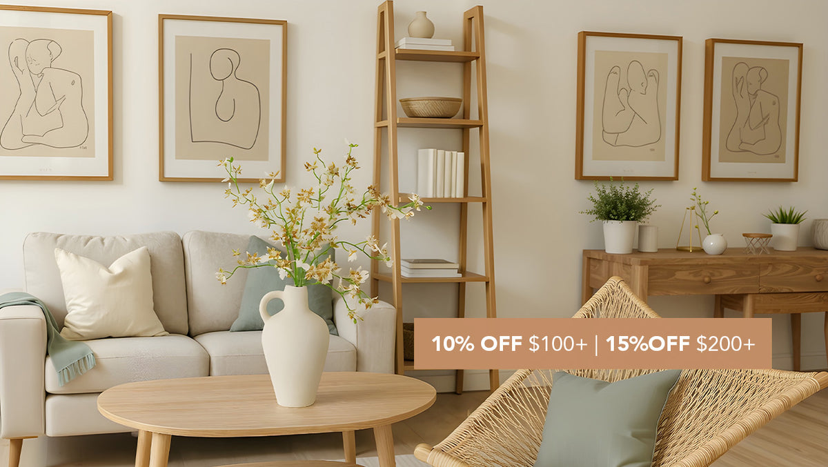 Artificial Oncidium flowers in a cream white ceramic vase displayed on a wood coffee table in a warm minimalist living room sale banner.