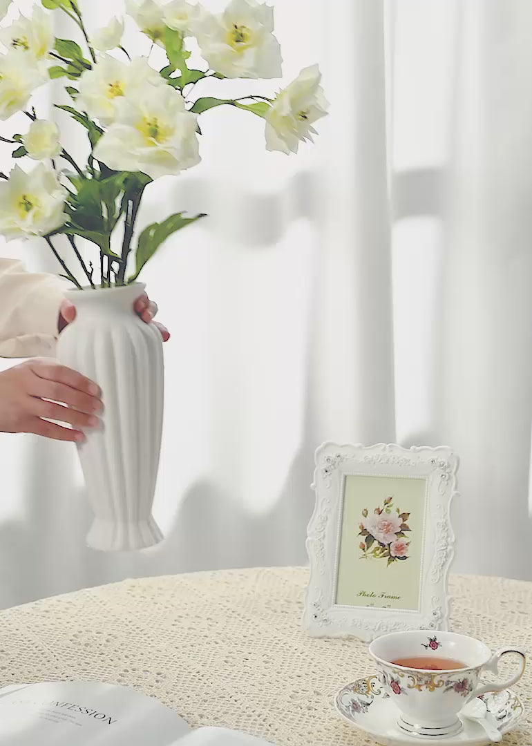 The artificial cream white floral arrangement against a white or retro background seamlessly blends modern sophistication with retro elegance.