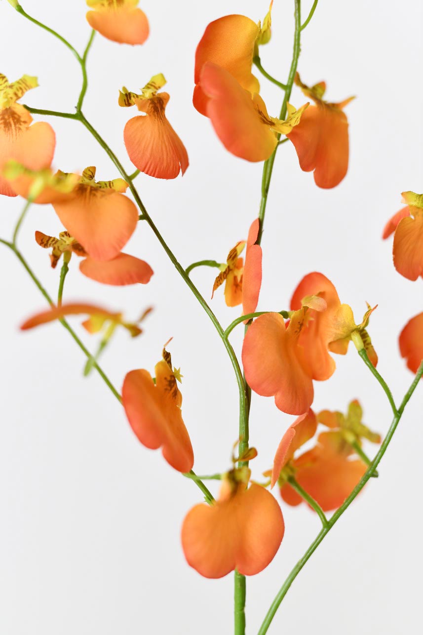 Artificial orange dancing orchid silk flowers with a bright green flower path. The arrangement looks realistic, with lifelike blooms and bright green stems.