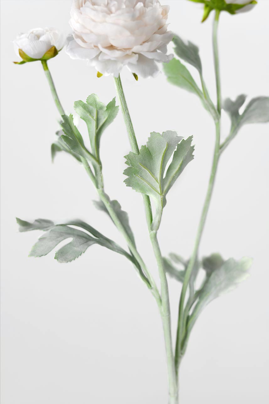 A close-up detail of Ranunculus silk flowers, creates a textured medley of foliage.