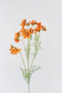 A bunch of faux orange cosmos flowers with artificial petals and stems.