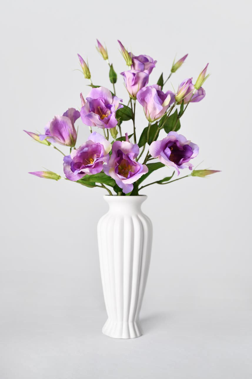 Faux lisianthus flowers in white background with bright colors and natural growth of buds. It is suitable as a centerpiece or in a floral bouquet.