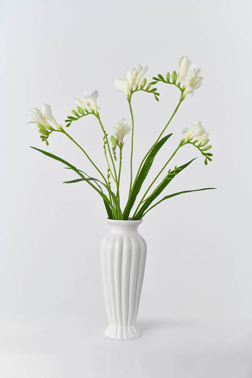 An artificial freesia flower in cream white color that is perfect for any floral arrangement.
