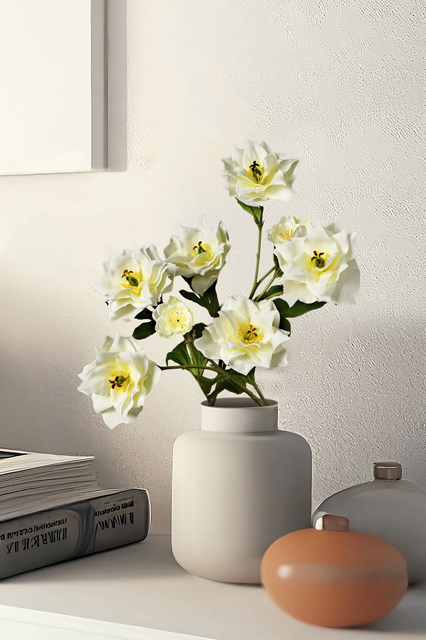 The creamy white artificial clematis in the blue vase simulates the real flower in full bloom and it has a unique shape.