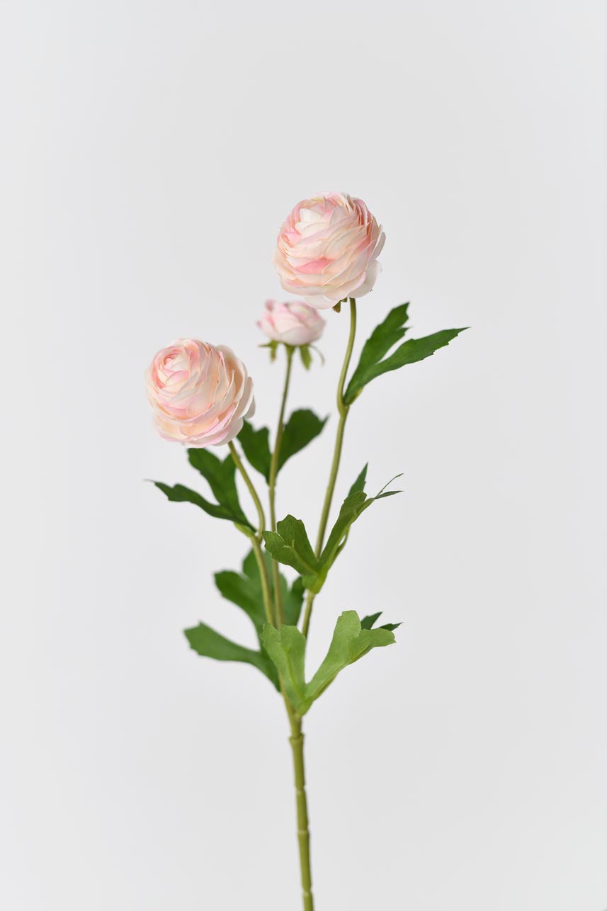 Artificial silk flowers in light pink with bright green leaves arranged in a blooming arrangement
