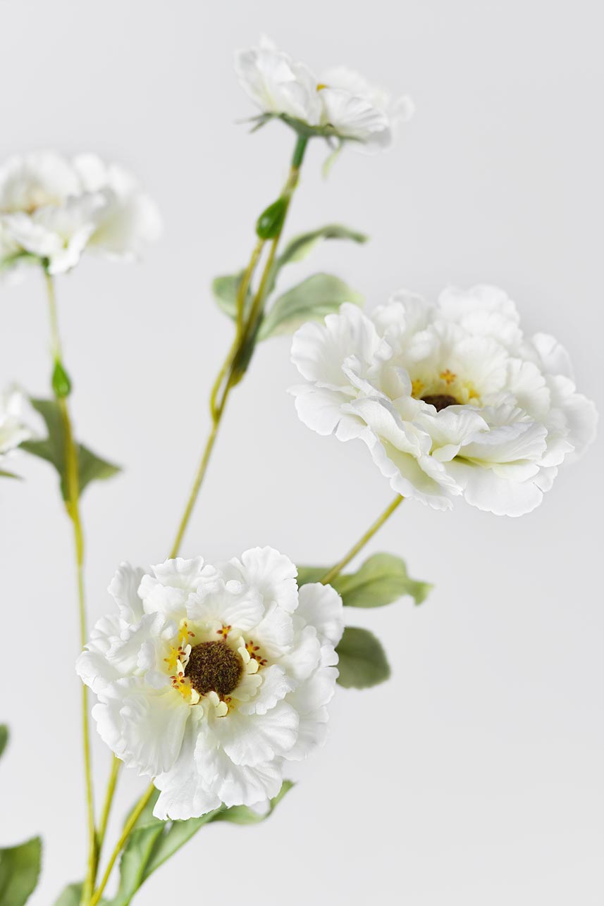 A close-up detail of cream-white lotus crane peony fake flowers with green leaves, adding a chic touch to your home style home.