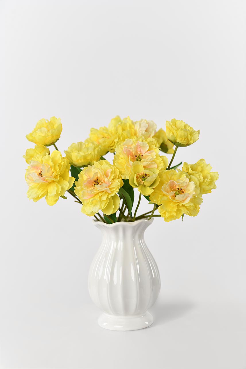 A vase filled with beautiful yellow real touch peony flowers, perfect for creating stunning floral arrangements.