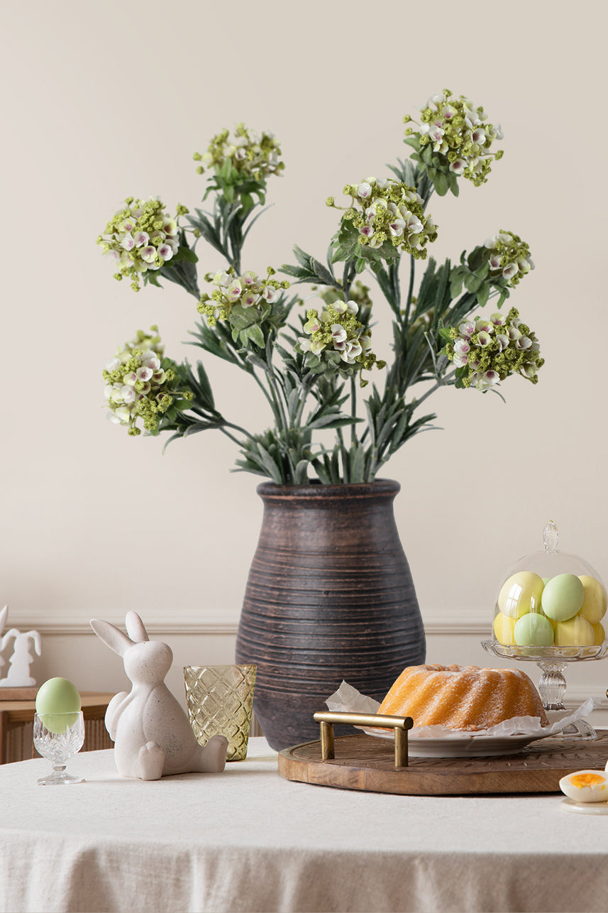 The artificial sweet alyssum is uniquely shaped and can be placed in a brown glass vase. The cluster of many small flowers makes it look more three-dimensional.