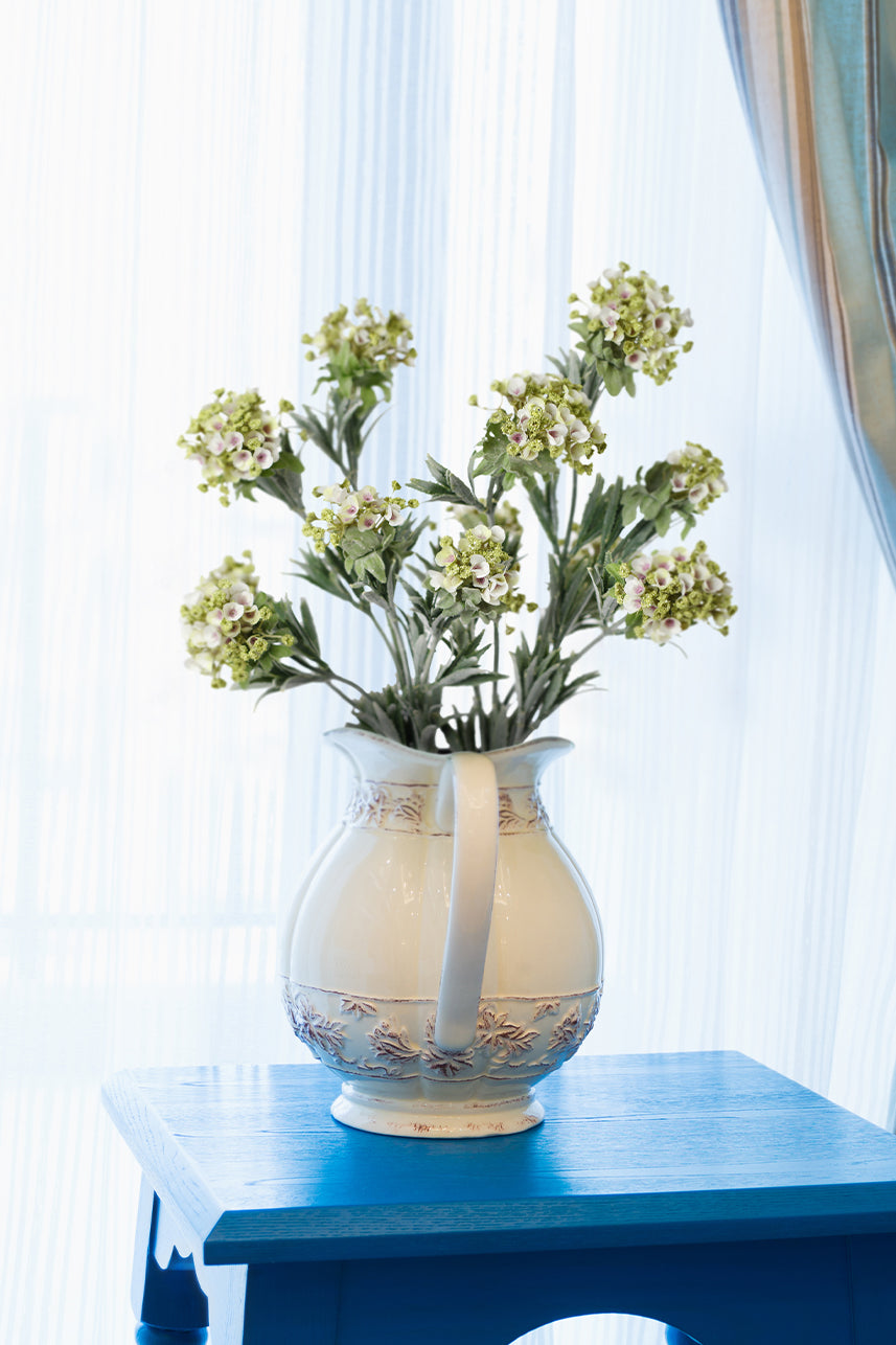 Capture the beauty of nature with this lifelike white Sweet Alyssum fake flower, elegantly displayed in a white vase.