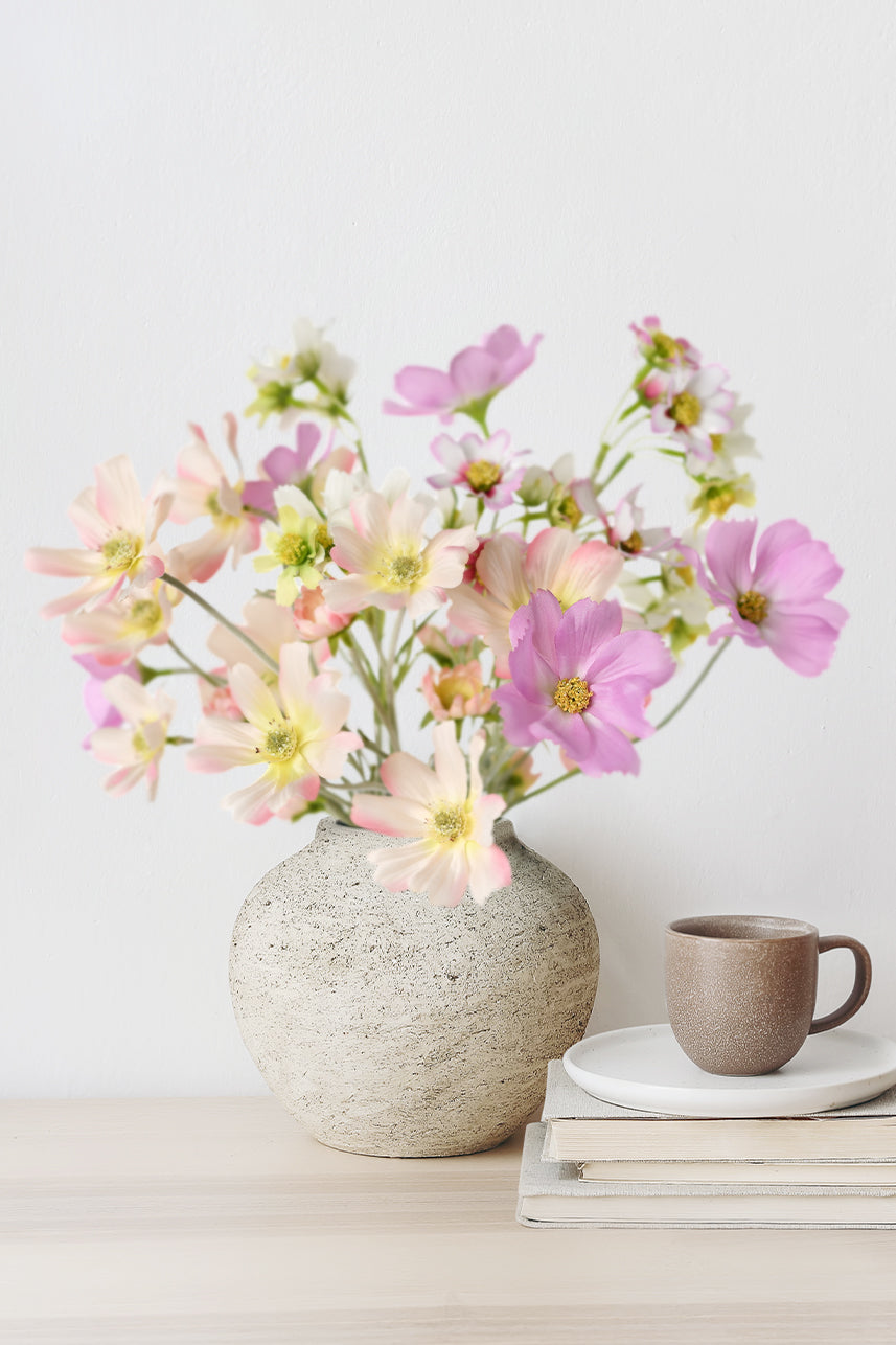 The pink artificial cosmos gives a playful and cute look and makes a great floral arrangement when placed in a white vase.