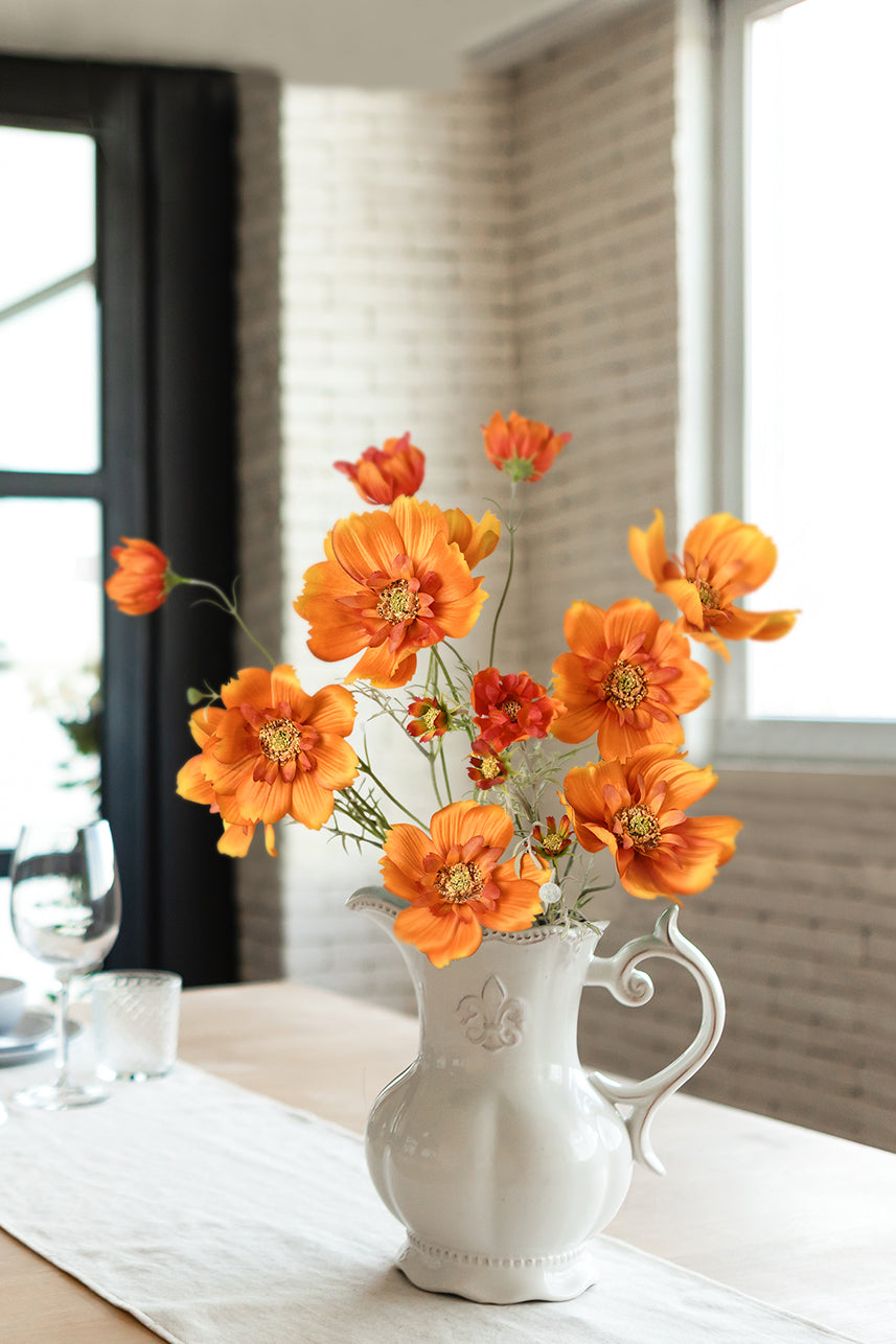 The bright orange cosmos sulphureus is placed in a white vase, and it can be placed on the kitchen island as a home decoration.