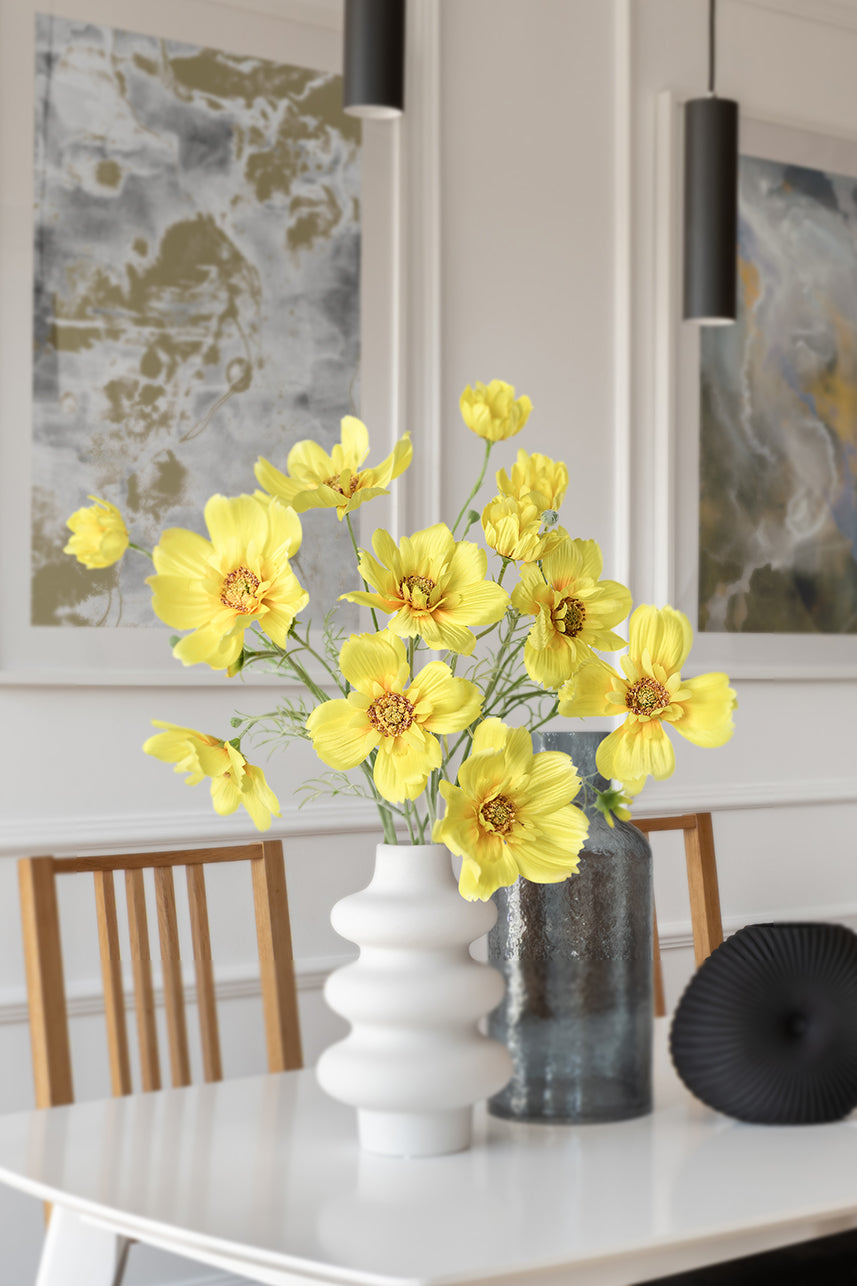 Yellow artificial cosmos sulphureus are placed in uniquely shaped vases, making this floral arrangement suitable for many styles of home design.