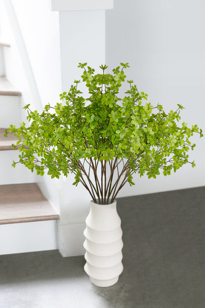 Delicate light green artificial Enkianthus Perulatus blossoms arranged in a white vase, infusing the space with natural grace and tranquility.