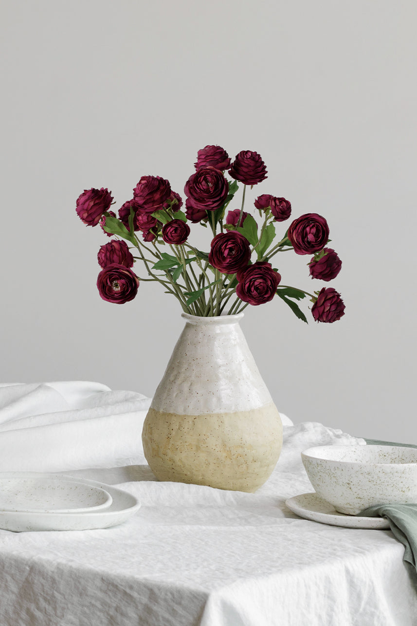 When the artificial faux ranunculus blends with the white background, you will feel the artistic atmosphere in it.