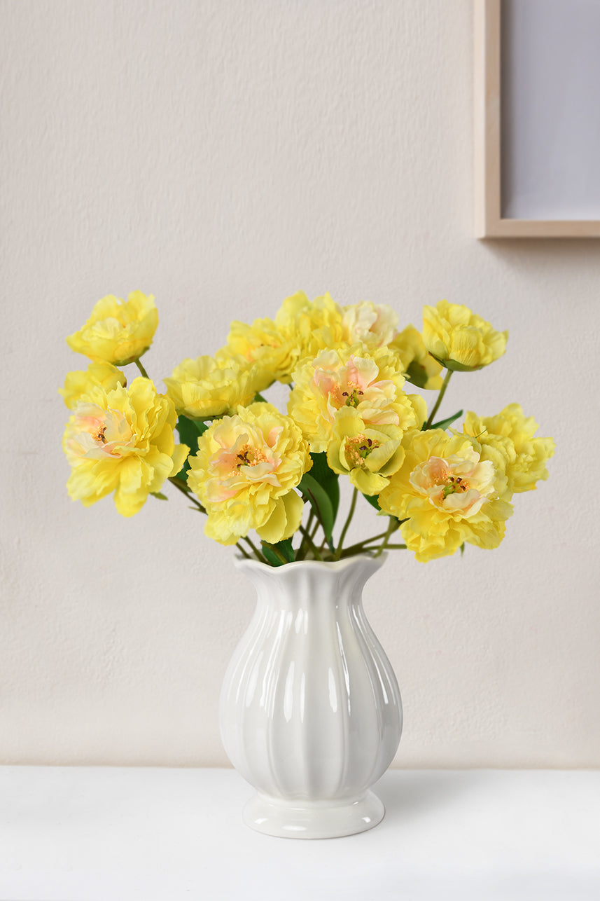 Sunny yellow faux Peony flowers elegantly arranged in a white vase, brightening up the home decor with their cheerful and vibrant beauty.
