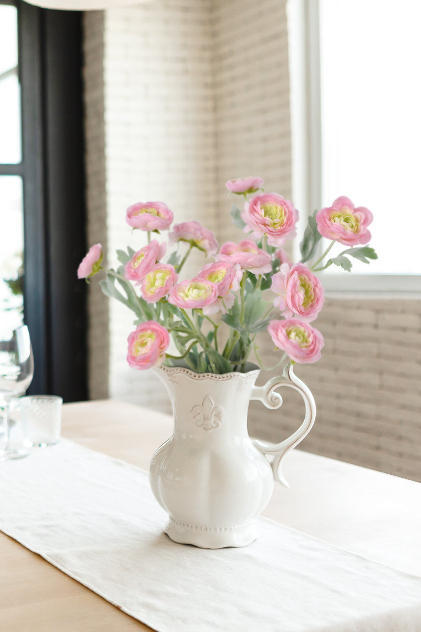 Home decor comes alive with the exquisite beauty of pink mauve artificial Ranunculus flower branches showcased in a white vase.