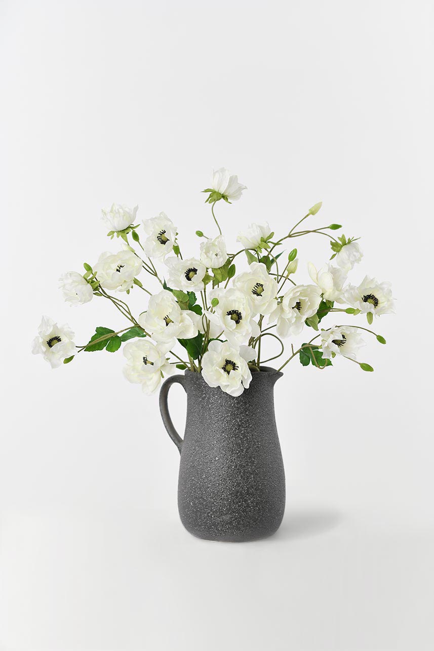 A long-stemmed cream and white fake anemone flower, 37 inches tall, suitable for use in vases or floral arrangements.