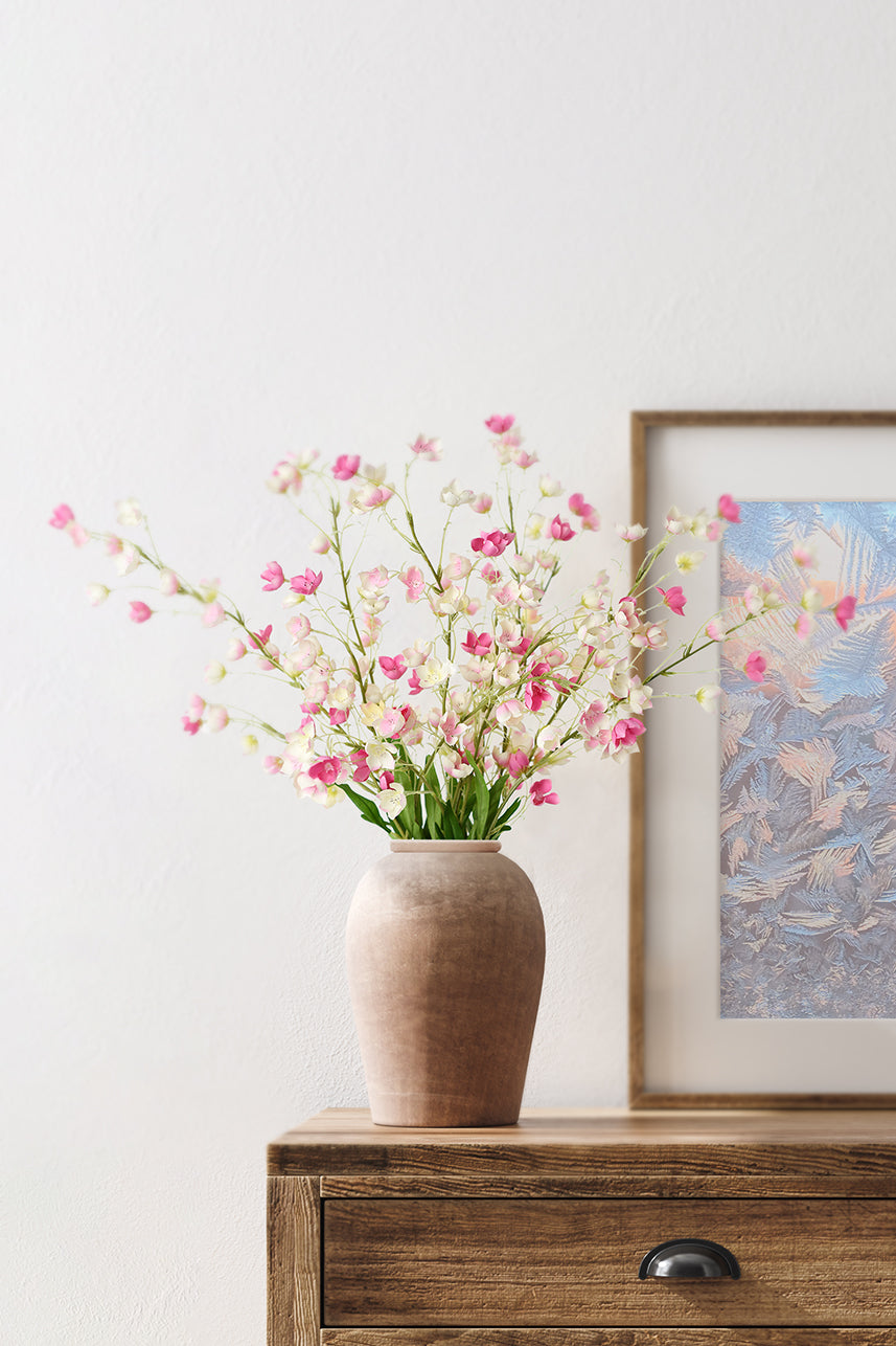 Pink artificial enkianthu flowers bring spring to the home, and in a minimalist home scene the floral arrangements are placed in brown vases.