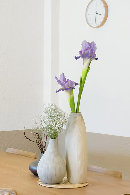 Two bundle of beautiful purple Iris Silk flowers arrangement in a ceramic vase, decor on the dinning room table.