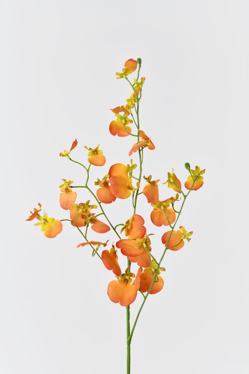 A tall vase filled with artificial dancing orchid flowers in shades of orange. The flowers are long and slender, with realistic-looking petals and bright green stems adding a natural element to the display.