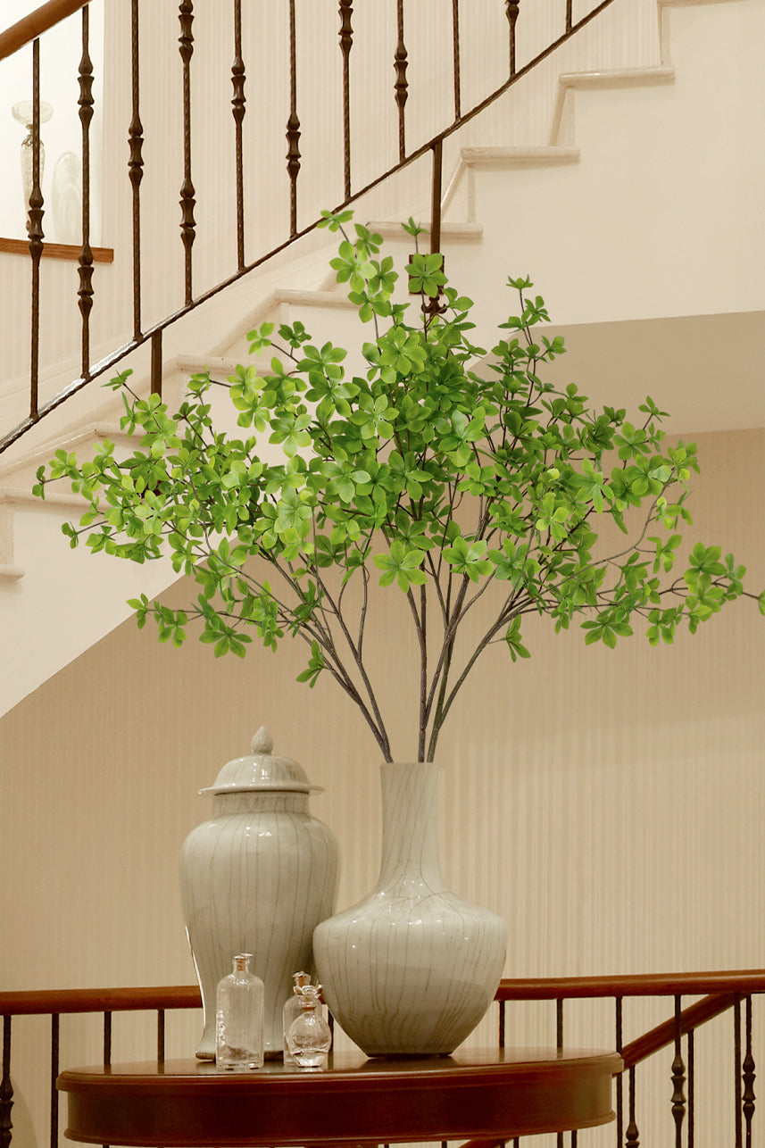 The artificial enkianthus perulatus placed in a ceramic vase beautifies the stairwell, and its unfurling branches bring greenery to the home.