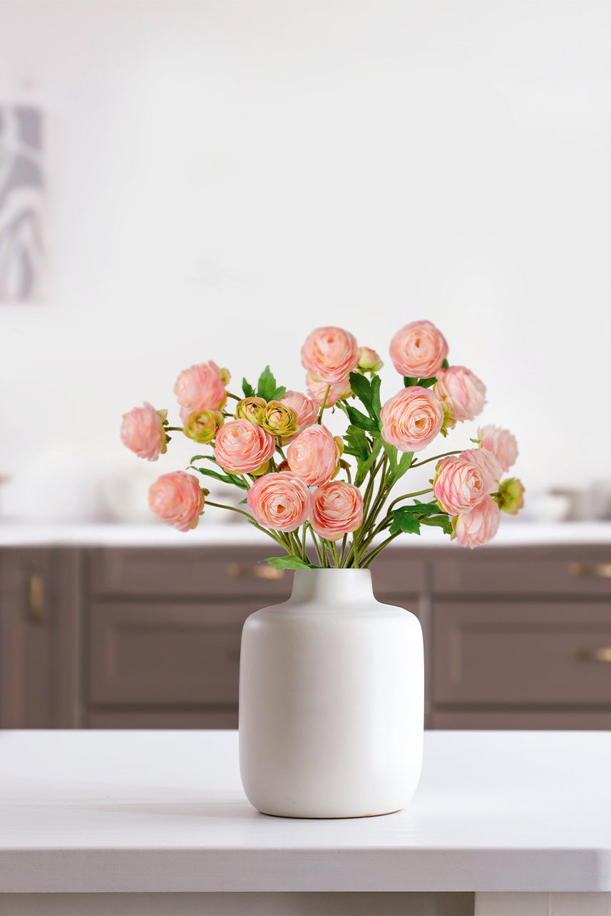 The pink artificial ranunculus is placed in a white vase, it is suitable for home scenes such as kitchen or living room.