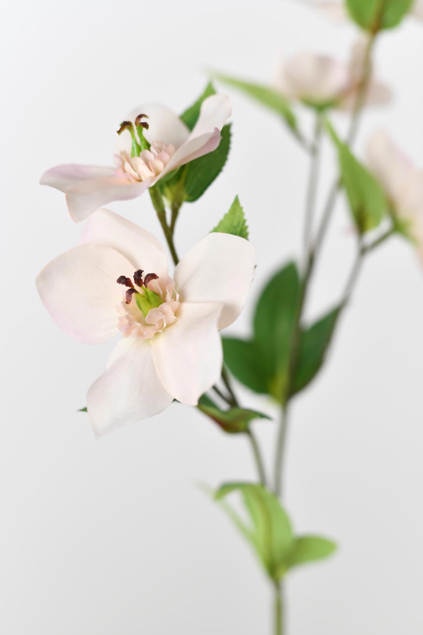 A detailed description of artificial Helleborus blossoms featuring five peach-pink realistic petals surrounding pink and green pistils.