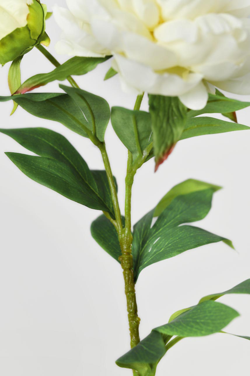 A close-up detail of phoenix peony fake flowers with green leaves, adding a chic touch to your home.