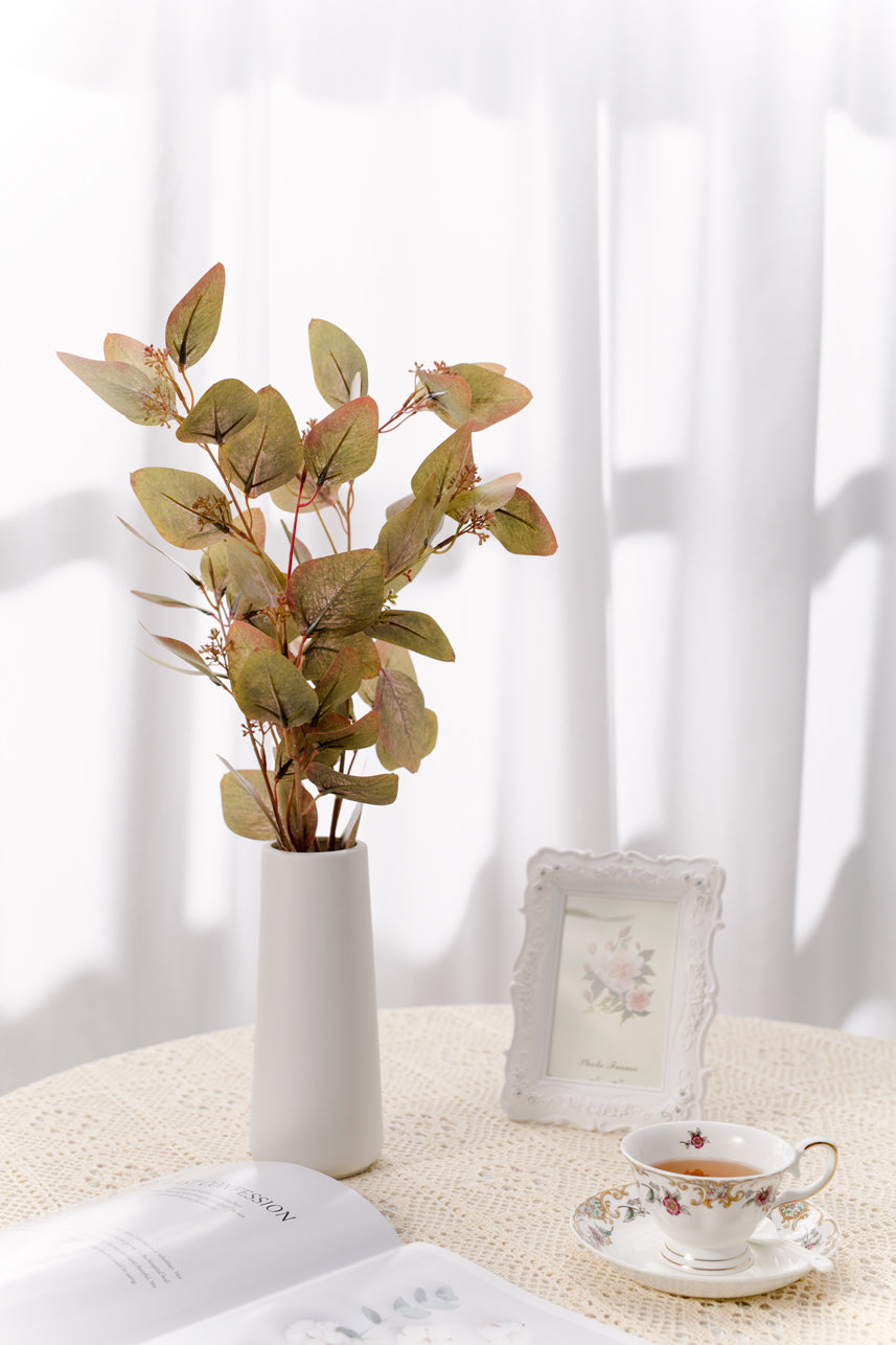 The high-quality plastic plants can adorn your home interior, try this simple shape of a faux branch. The burgundy-green foliage of the artificial stem is full of nature&