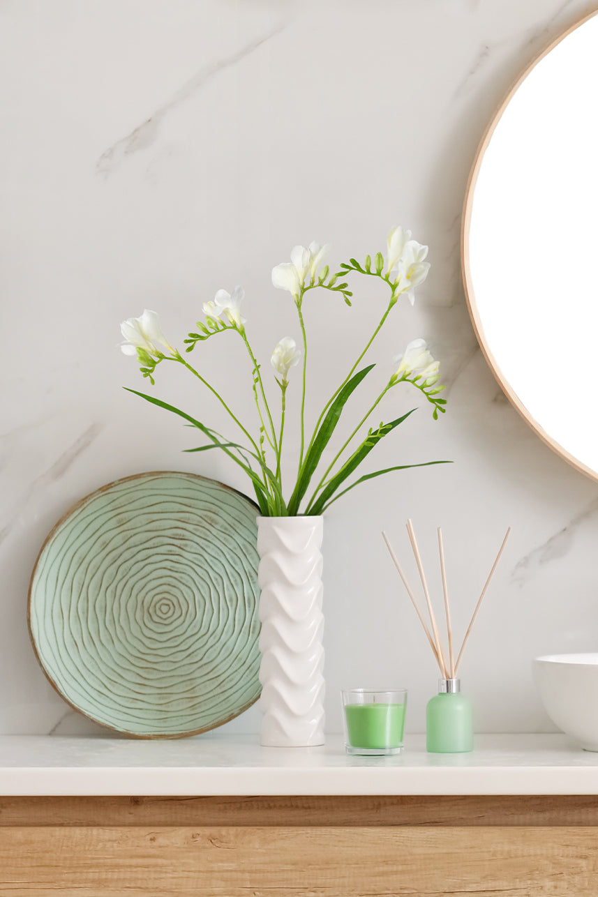 The cream white artificial freesia flower brings a fresh and natural feeling to the home scene. When it is inserted into a white vase, it is suitable for placement in the bathroom.