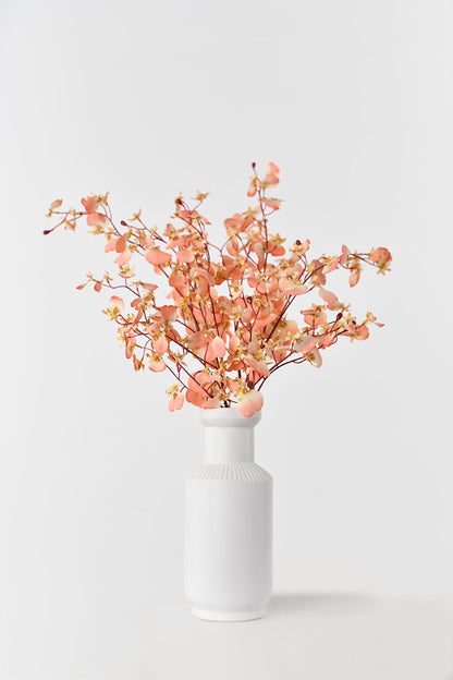 Silkfloras fake blooming coral pink dancing orchid flowers in a white vase, a stunning and lifelike addition to your home decor.