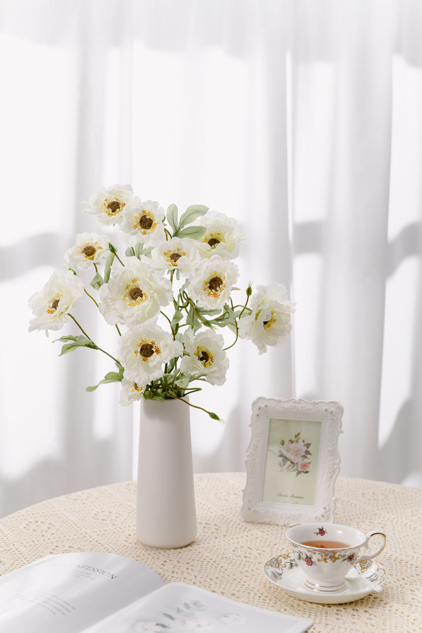 The budding to full bloom artificial cream-white lotus crane peony fake flowers are complete with a white vase perfect as a centerpiece. 