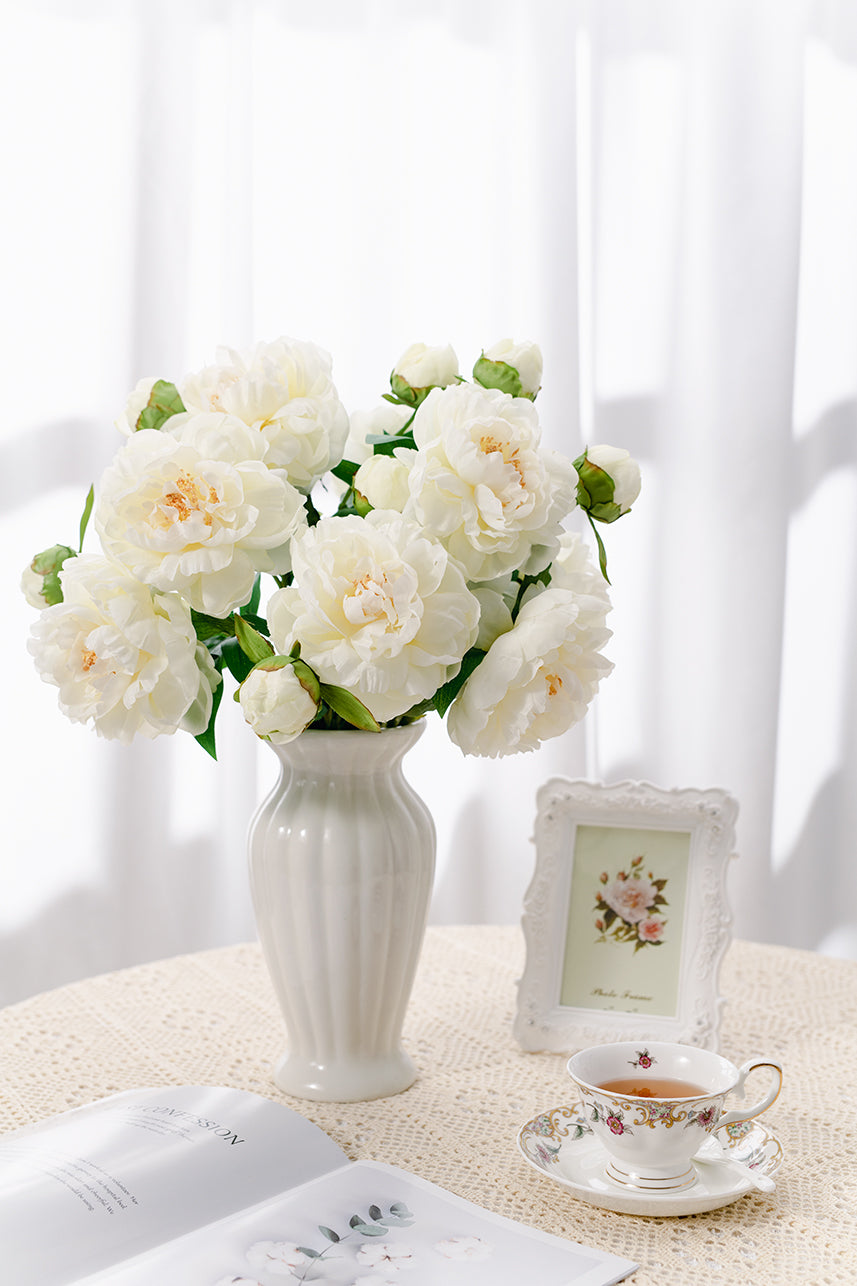 The budding to full bloom phoenix peony fake flowers complete with a white vase perfect as a centerpiece. 