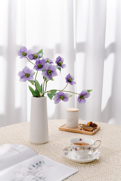 The budding to full bloom artificial light purple Helleborus silk blooms are complete with a white vase perfect as a centerpiece.  