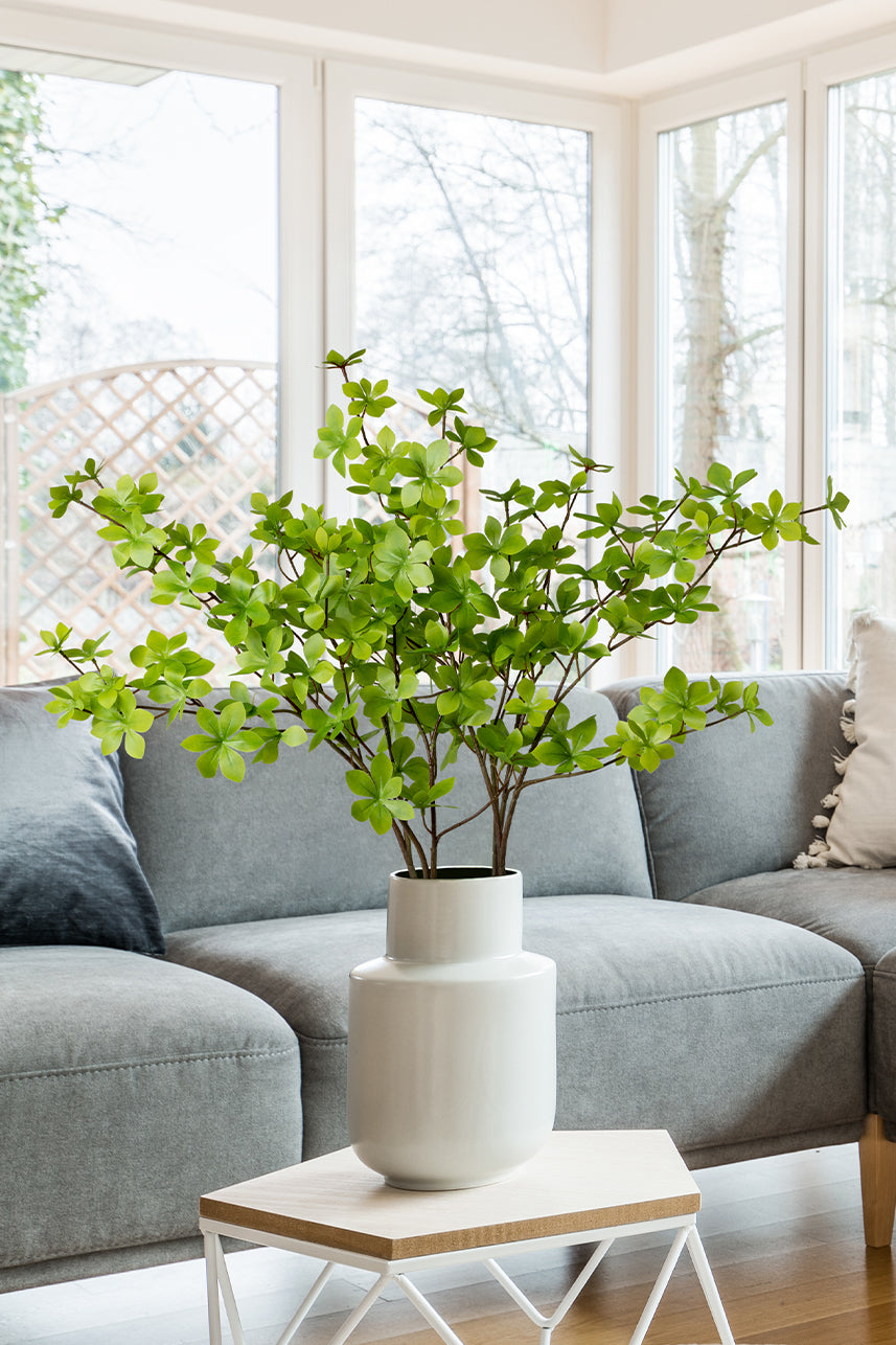 The artificial enkianthus perulatus next to the sofa is well integrated into the home scene, adding green life to the home.