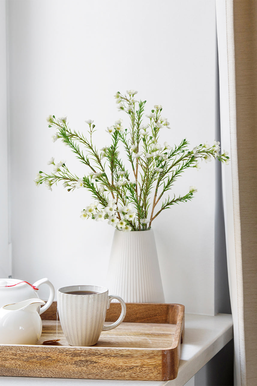 The white artificial wax flower on the windowsill seems to be more suitable for the modern home style, and you may put it aside when you enjoy afternoon tea.