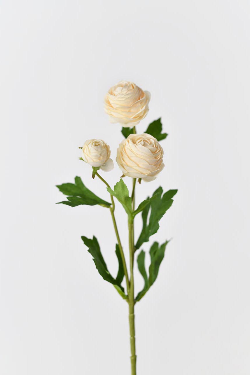 Artificial silk flowers in yellow peach with bright green leaves arranged in a blooming arrangement